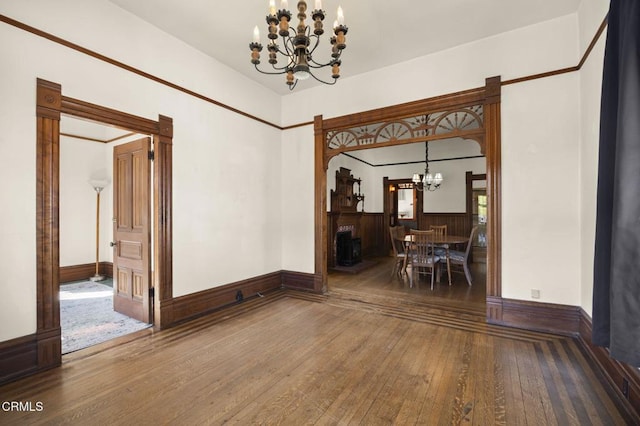 unfurnished dining area featuring an inviting chandelier and hardwood / wood-style floors