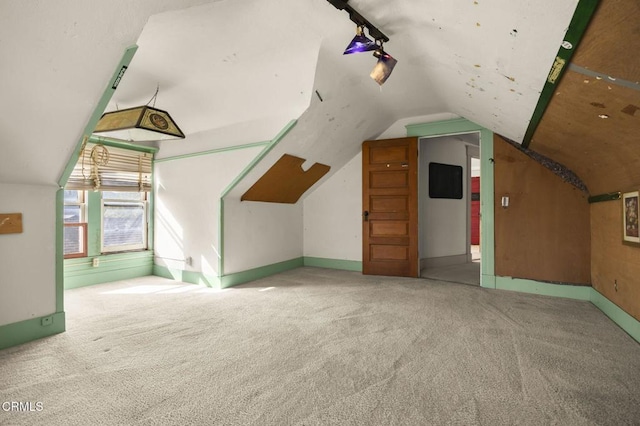 additional living space featuring vaulted ceiling and carpet