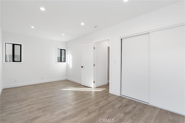 unfurnished bedroom featuring light hardwood / wood-style floors and a closet