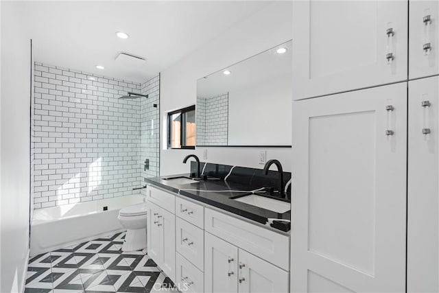 full bathroom with tiled shower / bath combo, vanity, and toilet