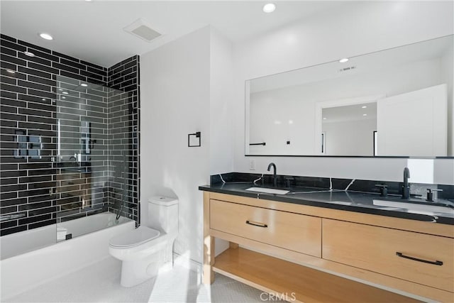 full bathroom featuring tiled shower / bath combo, vanity, tile patterned floors, and toilet