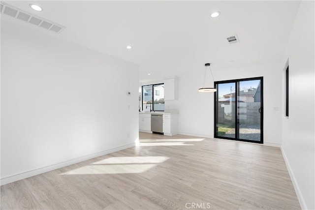 empty room with light hardwood / wood-style flooring and plenty of natural light