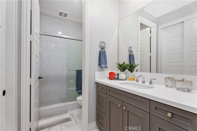 bathroom with walk in shower, vanity, and toilet