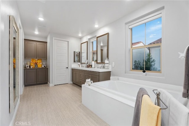 bathroom featuring vanity and a washtub