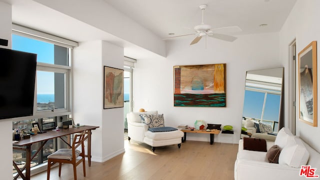 living room with ceiling fan, a healthy amount of sunlight, and light wood-type flooring