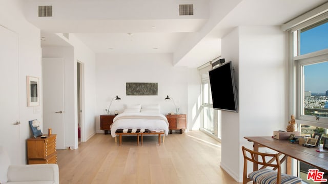 bedroom featuring multiple windows and light hardwood / wood-style flooring