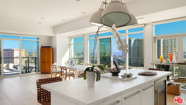 kitchen featuring light hardwood / wood-style flooring, plenty of natural light, a center island, wine cooler, and white cabinets