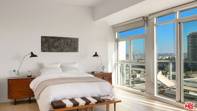 bedroom with hardwood / wood-style floors and multiple windows