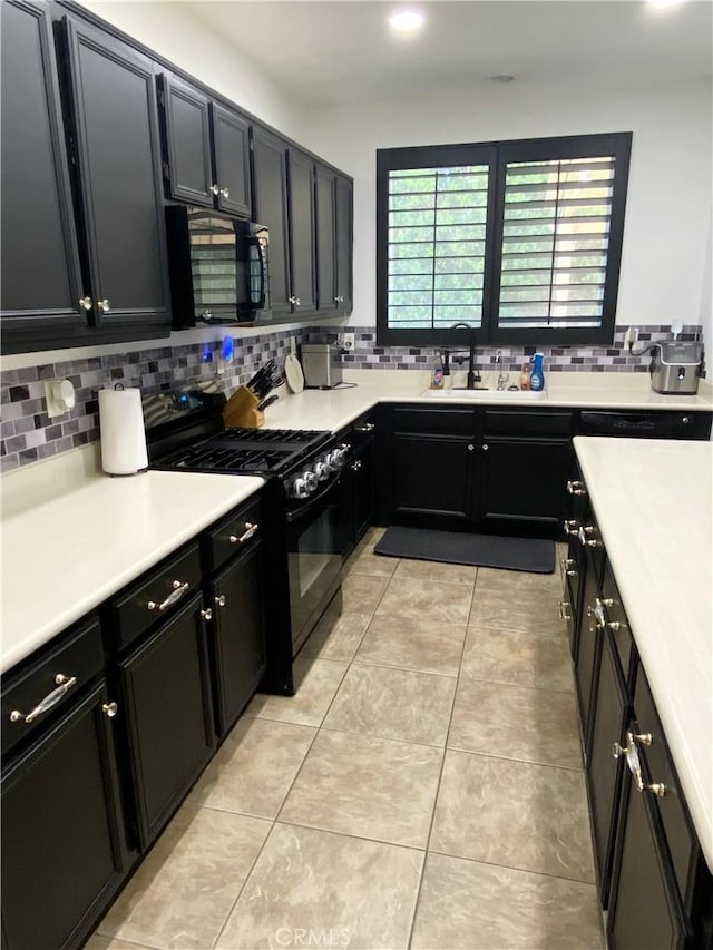 kitchen featuring backsplash, light tile patterned floors, sink, and black appliances