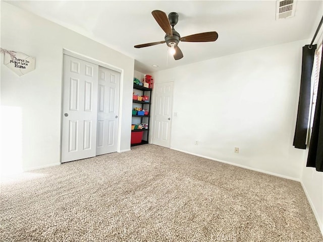 unfurnished bedroom with ceiling fan, a closet, and carpet