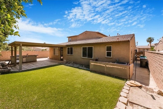 back of property with a patio area, a lawn, a fenced backyard, and stucco siding