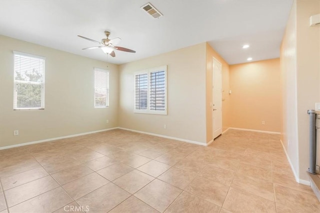 empty room with light tile patterned flooring, visible vents, baseboards, and ceiling fan