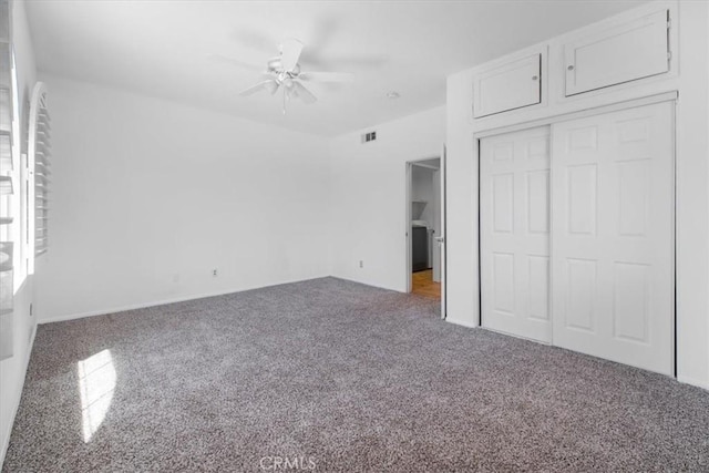 unfurnished bedroom with ceiling fan, a closet, visible vents, and carpet