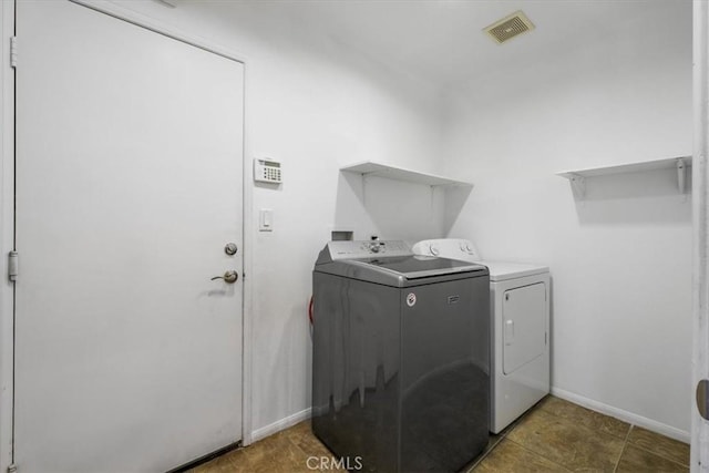 laundry room featuring baseboards, visible vents, washer and clothes dryer, and laundry area
