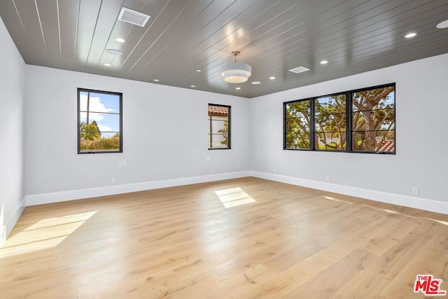 empty room featuring light hardwood / wood-style floors and wooden ceiling