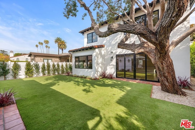 back of house featuring a lawn