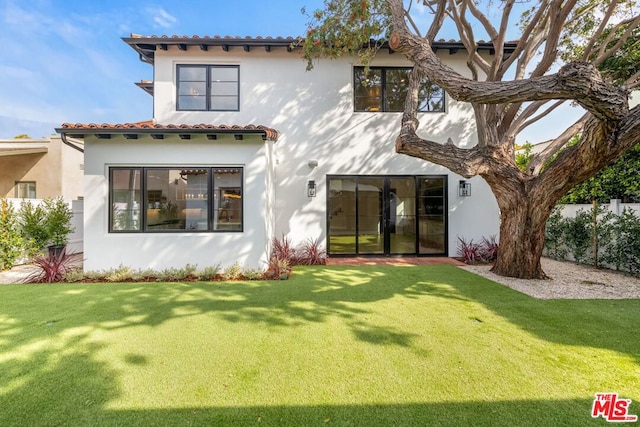 rear view of house with a yard and french doors