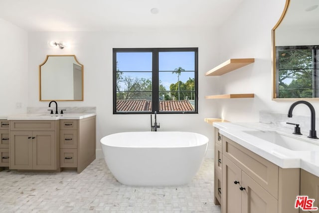 bathroom with a washtub, vanity, and a wealth of natural light