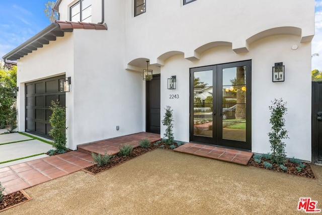 doorway to property with a garage and french doors