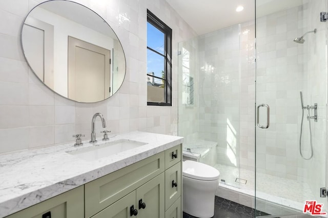 bathroom featuring tasteful backsplash, vanity, tile walls, and a shower with shower door