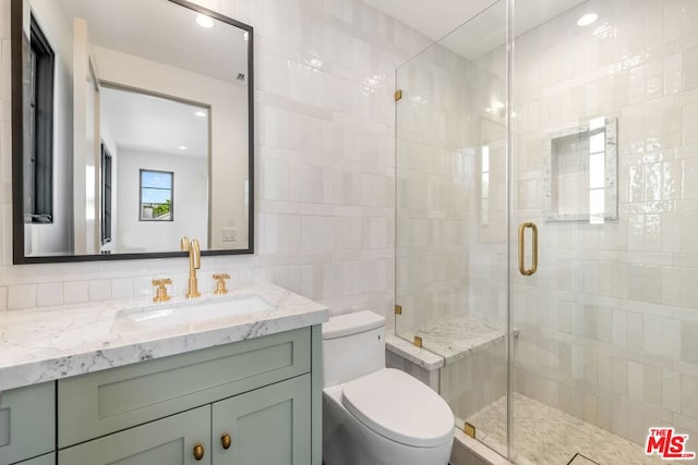 bathroom featuring vanity, tile walls, an enclosed shower, and toilet