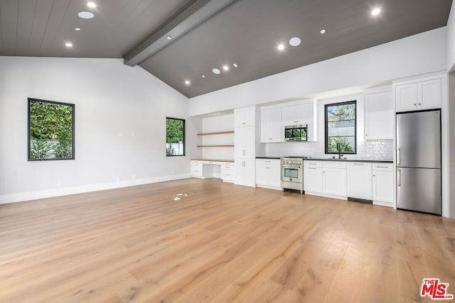 kitchen with white cabinetry, appliances with stainless steel finishes, beam ceiling, and decorative backsplash