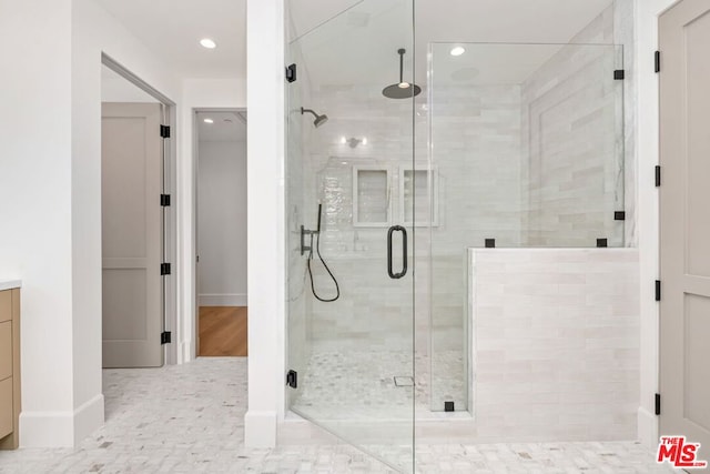 bathroom featuring vanity and a shower with door