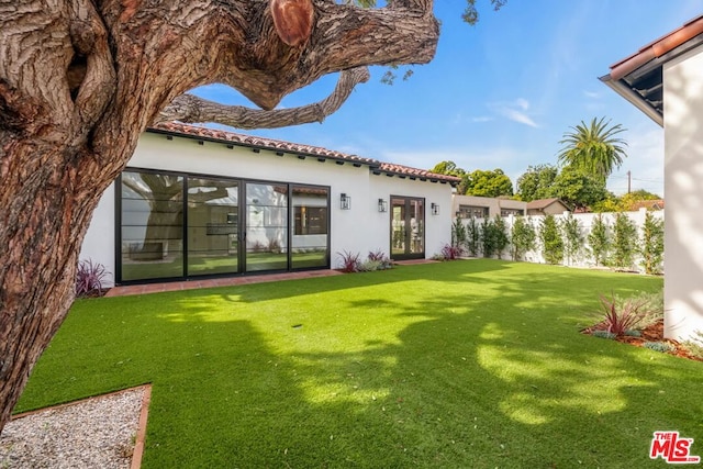 rear view of property with a yard