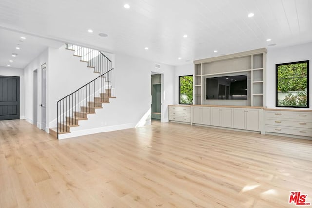 unfurnished living room with wooden ceiling, light hardwood / wood-style flooring, and a wealth of natural light