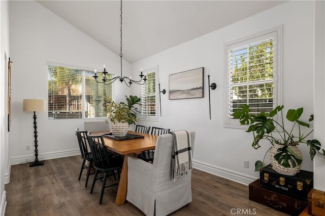 dining area featuring dark hardwood / wood-style flooring, lofted ceiling, and a chandelier