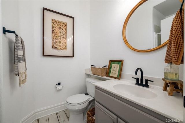 bathroom with vanity, wood-type flooring, and toilet