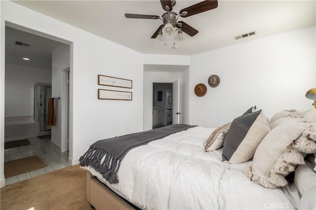 bedroom with ceiling fan, tile patterned floors, and ensuite bath