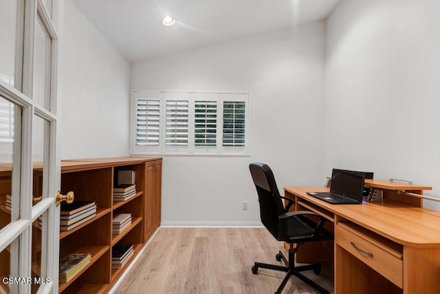 office space with lofted ceiling and light wood-type flooring