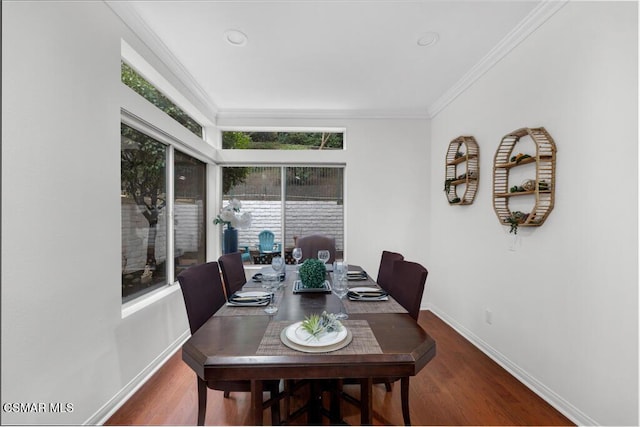 dining space with crown molding and dark hardwood / wood-style flooring