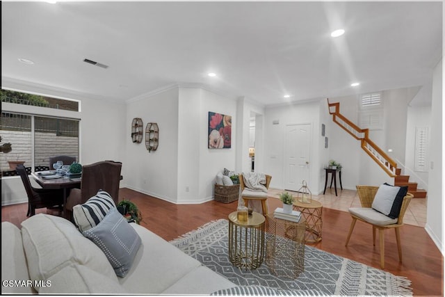 living room featuring wood-type flooring and crown molding