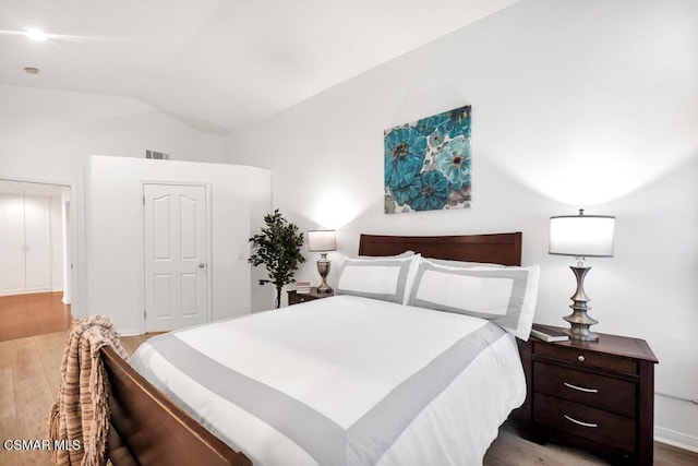 bedroom featuring lofted ceiling and light wood-type flooring