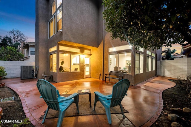 patio terrace at dusk featuring central AC