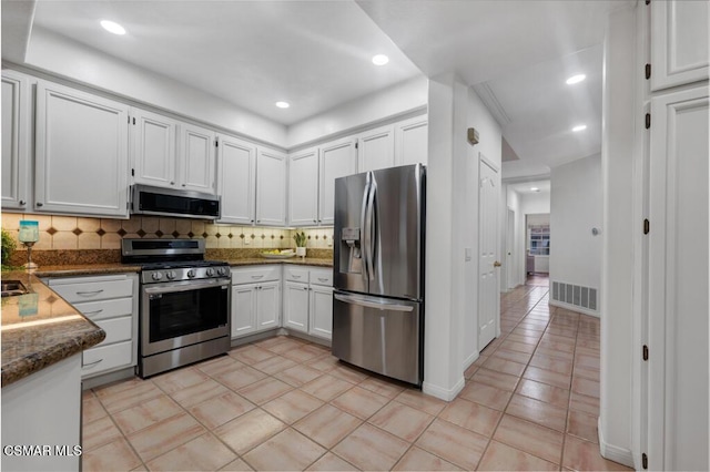 kitchen featuring backsplash, stainless steel appliances, and white cabinets