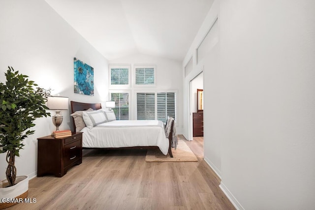 bedroom with light hardwood / wood-style flooring and high vaulted ceiling