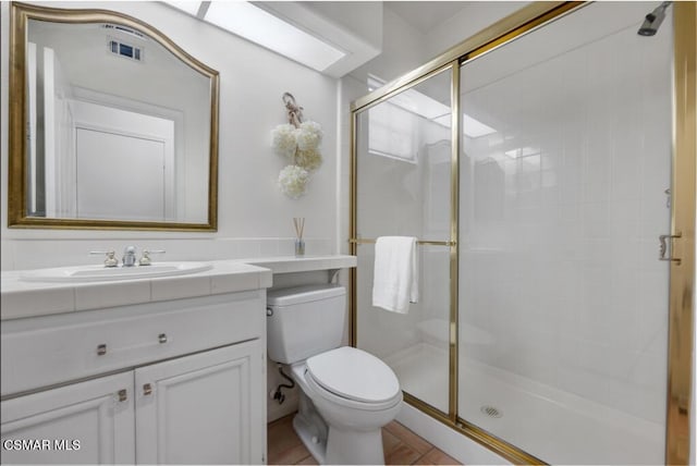 bathroom featuring vanity, toilet, and an enclosed shower