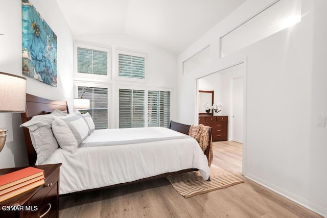 bedroom with vaulted ceiling and light hardwood / wood-style floors