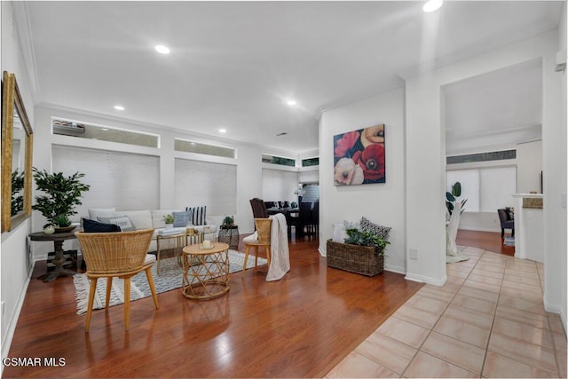 living area featuring ornamental molding and light hardwood / wood-style flooring