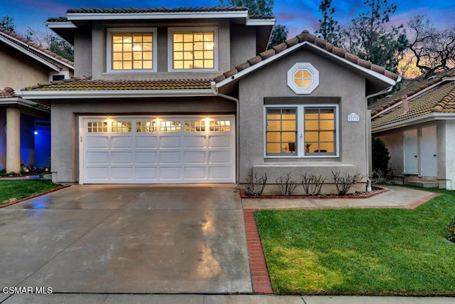 view of front facade with a garage and a lawn