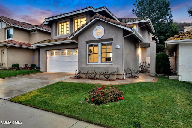 view of front of house featuring a garage and a yard