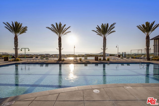 pool at dusk with a patio