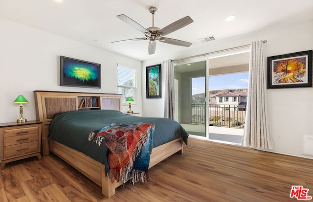 bedroom featuring multiple windows, hardwood / wood-style flooring, access to outside, and ceiling fan