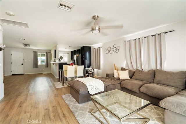 living room featuring ceiling fan and light wood-type flooring