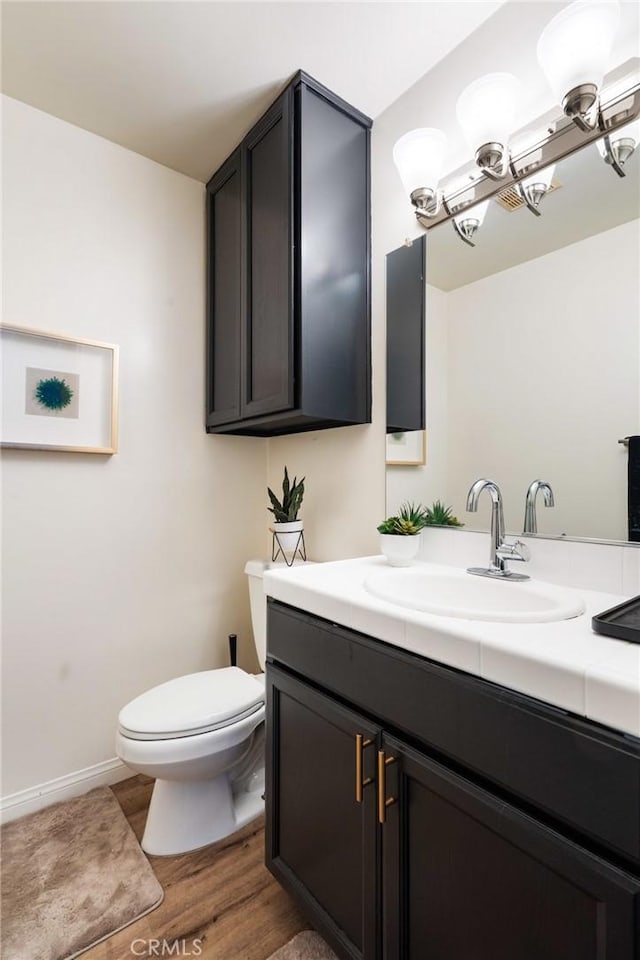 bathroom with vanity, a notable chandelier, wood-type flooring, and toilet