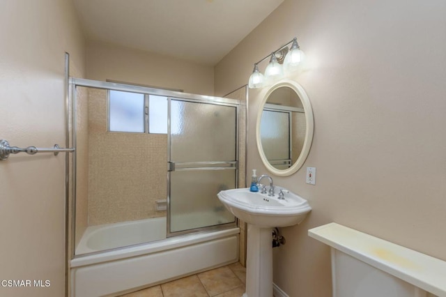 bathroom with toilet, shower / bath combination with glass door, and tile patterned flooring