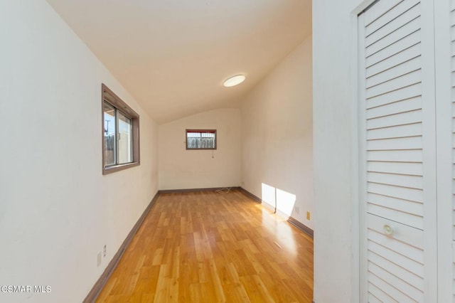 hall featuring vaulted ceiling and light hardwood / wood-style floors